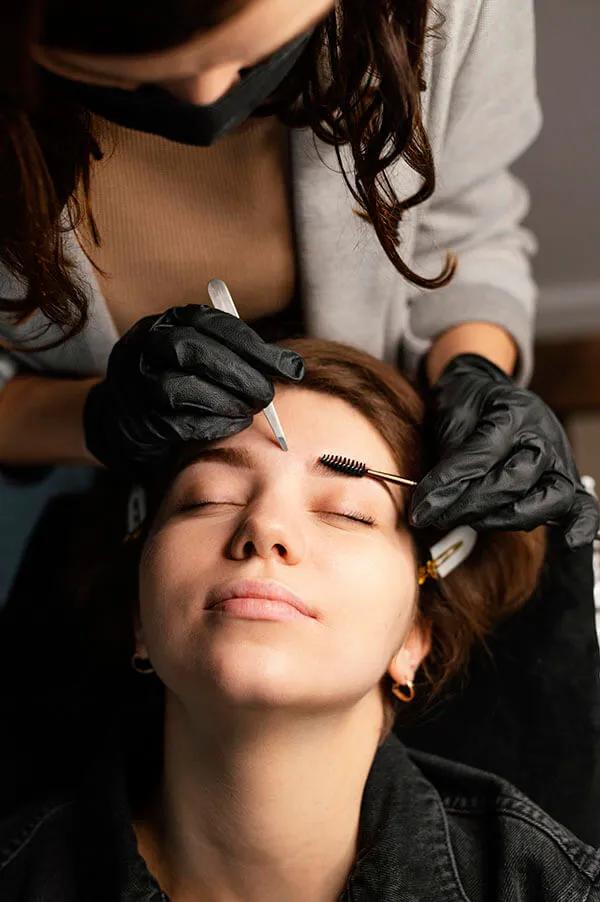 young brunette woman microblading eyebrows