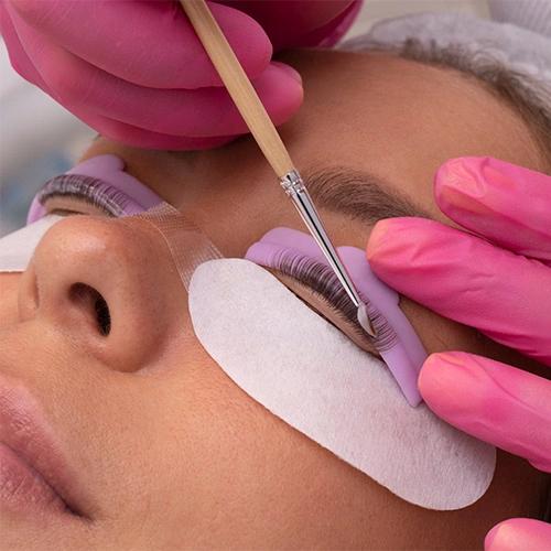 beautician is lifting the woman's eye lashes