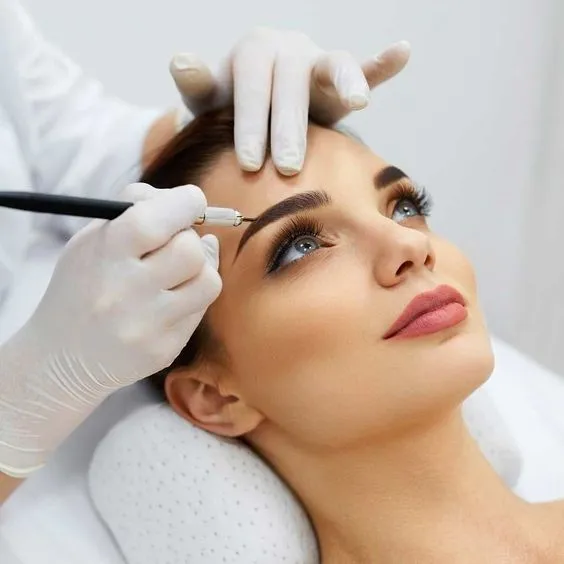 beautician is microblading young beautiful woman